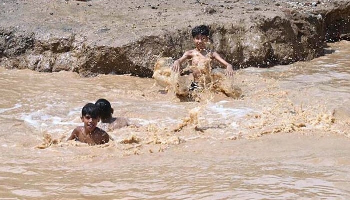 A representational image showing children enjoying bath in the rain water in a muddy pond in Islamabad. — APP/File