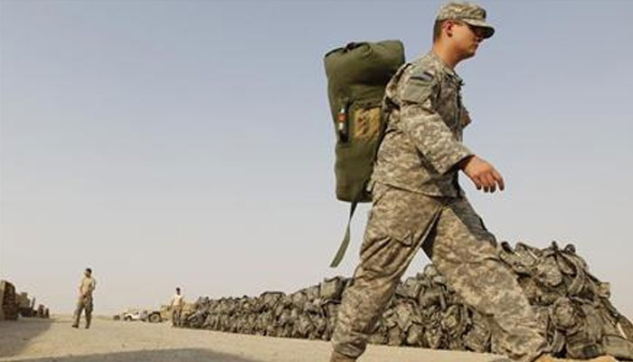 A US soldier from the 1st Battalion,116th Infantry Regiment, carries his bag as he prepares to pull out from Iraq to Kuwait, at Tallil Air Base near Nassiriya, 300 km (185 miles) southeast of Baghdad, August 15, 2010. — Reuters