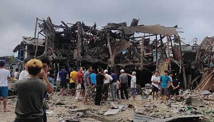 This UGC photo taken and obtained from the Facebook account of Mai So Jar on September 6, 2024 shows people gathering around a destroyed building following an air strike in Namhkham township in Myanmar’s northern Shan state.  — AFP