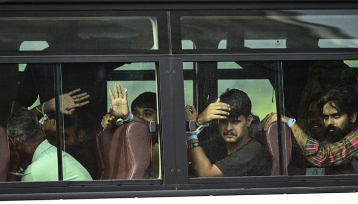 The deported 130 Indian migrants seen on a charter bus.— AFP/file