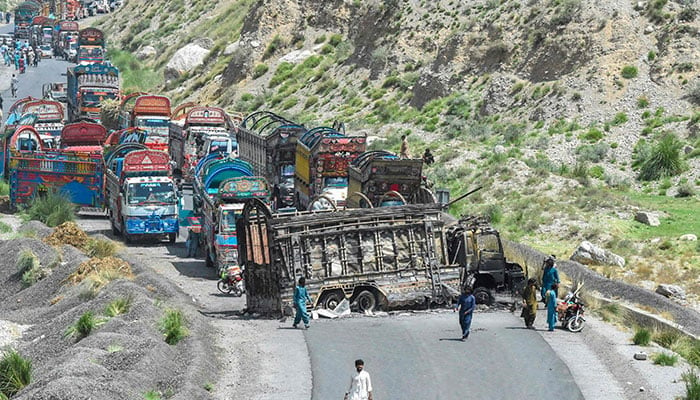 People look at a charred vehicle near a collapsed railway bridge a day after an attack carried out by terrorists in Bolan district, Balochistan on August 27, 2024. — AFP