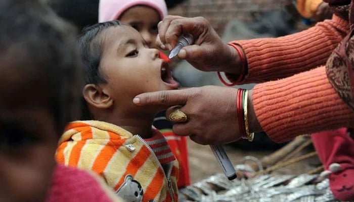 A child is being administered polio drops by a health worker. — AFP/File