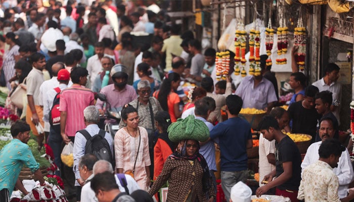 People walk through a crowded market in Mumbai, India, December 22, 2022. — Reuters