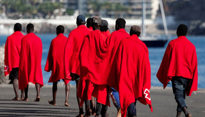 A group of migrants walk in the port of Arguineguin to be assisted by the Red Cross after disembarking from a Spanish coast guard vessel, in the island of Gran Canaria, Spain, October 12, 2023. — Reuters