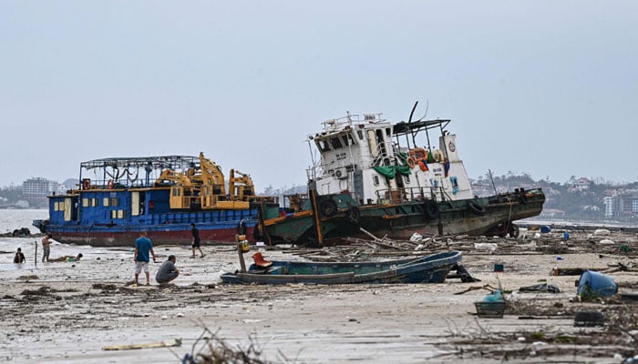 People inspect damaged boats on Bai Chay beach after Super Typhoon Yagi hit Ha Long, in Quang Ninh province, on September 8, 2024. — AFP