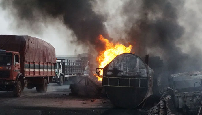 A representational image showing trucks driving past fuel-laden tanker which exploded and fell after a collision. — AFP/File