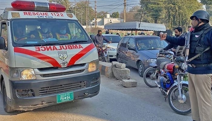 This representational image shows a police official guiding an ambulance on the road in KP — AFP/File