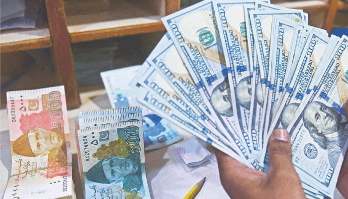 A foreign currency dealer counts US dollars at a shop in Karachi, Pakistan, May 19, 2022. — AFP/File