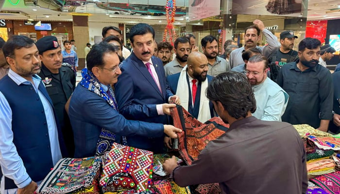 Governor Khyber Pakhtunkhwa Faisal Karim Kundi asks to saller about a quilt made of dying art at a dying crafts exhibition held at a local mall in Islamabad seen in this image released on September 9, 2024. — Facebook/@FaisalKarimKundi