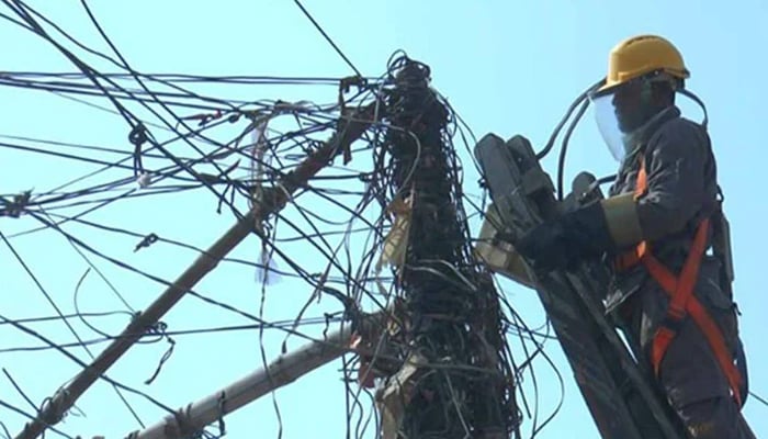 A representational image showing a KE personnel working on power lines. — KE website/File