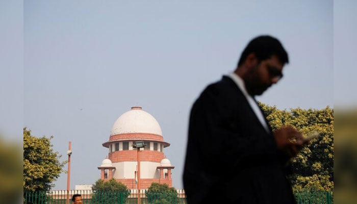 A lawyer looks into his mobile phone in front of Indias Supreme Court in New Delhi, December 11, 2023. — Reuters