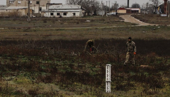 Ukrainian service members work next to a used MLRS cluster carrier shell in the village of Nova Zoria, amid Russias attack on Ukraine, in Kherson region, Ukraine December 6, 2022. — Reuters