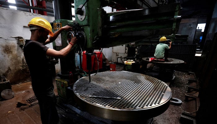 A worker makes a metal filter plate inside an industrial manufacturing unit on the outskirts of Ahmedabad, India, July 23, 2024. — Reuters