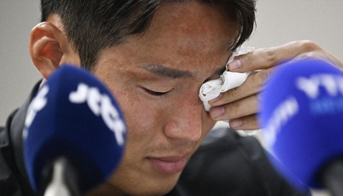 An emotional Son Jun-ho wipes away tears during a press conference where he denied Chinese charges of match-fixing. — AFP/file