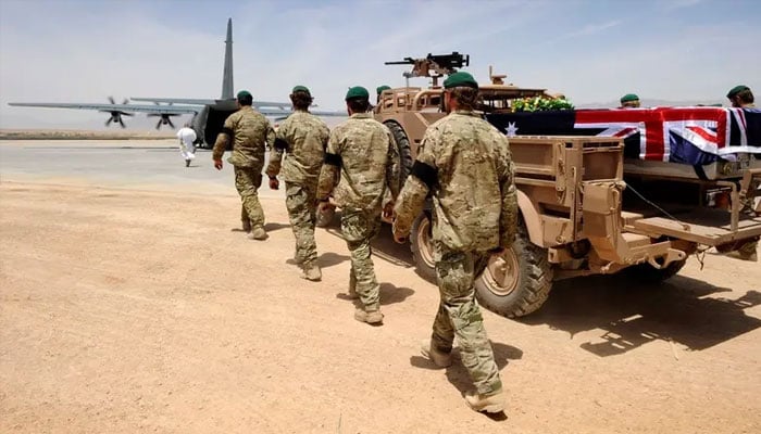 A special forces bearer party walks alongside Sergeant Brett Woods casket as he is driven to the awaiting C-130 aircraft at Tarin Kot Airfield in Uruzgan, Afghanistan May 28, 2011, in this photo provided by International Security Assistance Force (ISAF) Regional Command (South). —Reuters