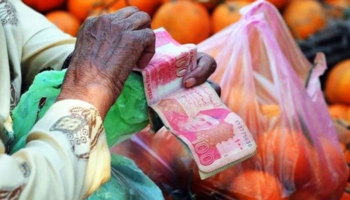 A person counts Rs100 notes in this undated image. — AFP/File