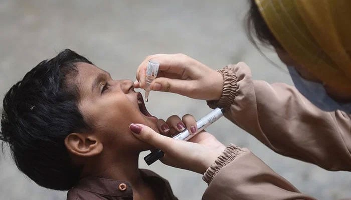 A health worker administers polio drops to a child during a door-to-door vaccination campaign in Karachi on August 7, 2023. — AFP