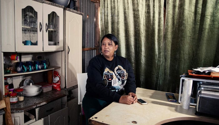 Ursula Felkers, a resident of Blikkiesdorp, a settlement on the outskirts of Cape Town, poses for a portrait in her house on August 19, 2024. — AFP