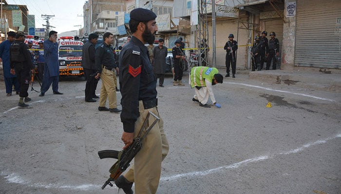 This representational image shows investigators gather at the shooting site in Quetta. — AFP/File