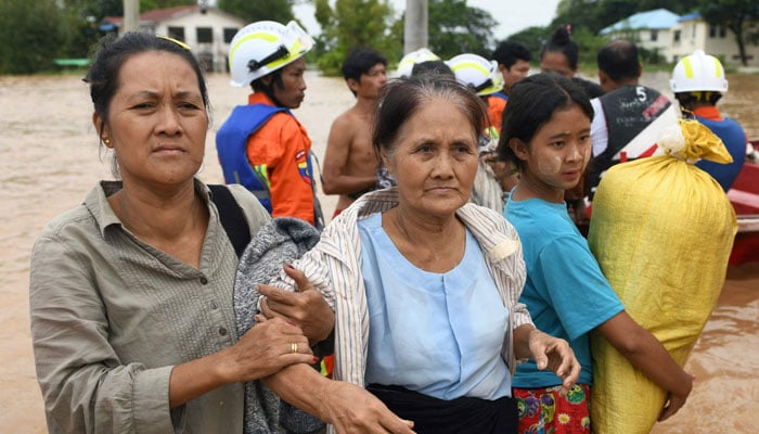 Residents walk through flood waters in Taungoo, Myanmar´s Bago region on September 14, 2024. — AFP