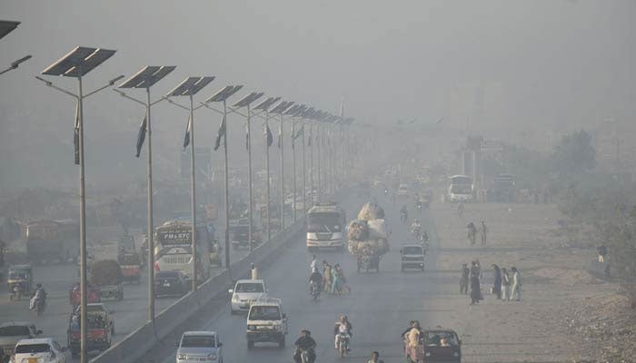 Motorists on their way during heavy smog in morning hours in Lahore on November 30, 2022. — Online