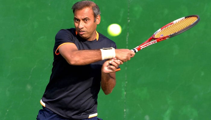 Pakistani tennis player Aqeel Khan while taking a shot. — APP/FIle