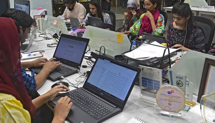 People work at their stations at the National Incubation Centre (NIC) in Lahore, Pakistan. — AFP/File