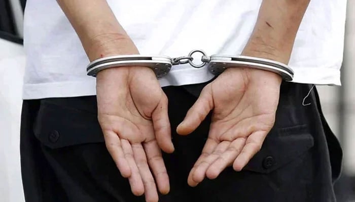 A representational image of a man in handcuffs. — APP/file