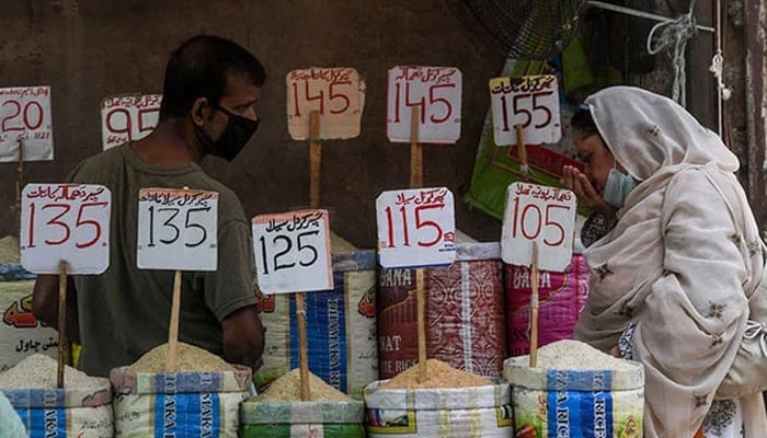 A woman checks the smell of rice at a market. — AFP/File