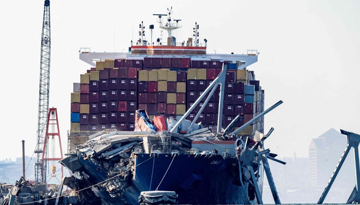 A section of the Francis Scott Key Bridge rests in the water next to the Dali container ship in Baltimore on May 13, 2024. — AFP