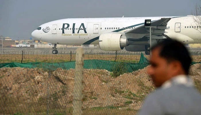 A Pakistani man looks on as a Pakistan International Airline (PIA) plane taxis on the runway in Islamabad. — AFP/file