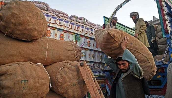 Representational image shows a labourer carrying a sack of potatoes at a fruit and vegetable market in Peshawar. — AFP/File