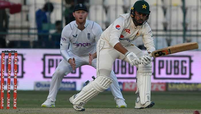 Faheem Ashraf (R) plays a shot as England´s captain Ben Stokes watches during the third day of the second cricket Test match between Pakistan and England in Multan on December 11, 2022. — AFP