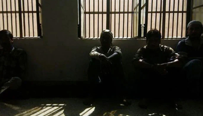 Prisoners sitting inside a dark lockup are seen in this undated image. — AFP/File