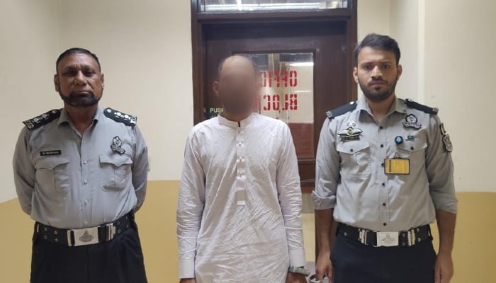 FIA officials have arrested a passenger travelling abroad on fake documents and the arrested person is between two FIA officers seen in this image released on September 20, 2024. — Facebook/@FIAAgencyOfficial