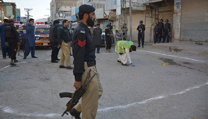 In this file photo, investigators gather at a shooting site in Quetta. — AFP/File