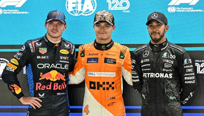 McLarens British driver Lando Norris (C) poses for photos after getting pole position, with second position Red Bull Racings Dutch driver Max Verstappen (L) and third position Mercedes British driver Lewis Hamilton after the qualifying session ahead of the Formula One Singapore Grand Prix night race in Singapore on September 21, 2024. — AFP