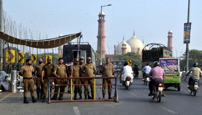 Police officials stand alert to avoid untoward incidents as security has been on high alert due to the Tehreek-e-Insaf (PTI) protest demonstration, near Greater Iqbal Park in Lahore on September 21, 2024. — PPI