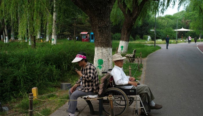 Elderly people rest at a park in Beijing on May 22. — Reuters/file