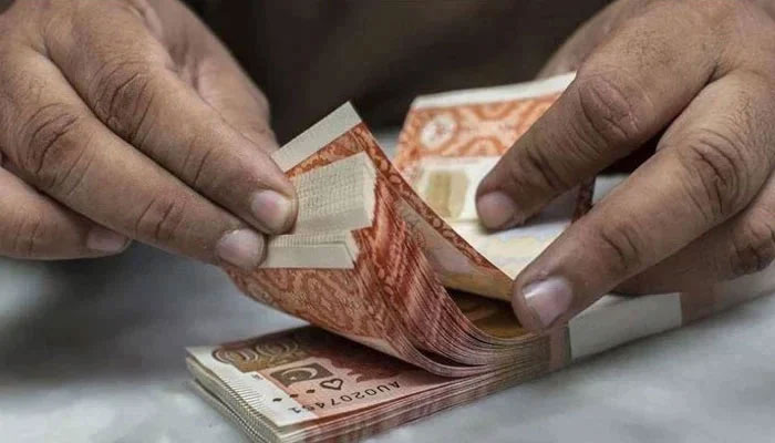 A currency dealer can be seen counting Rs5,000 notes. — AFP/file