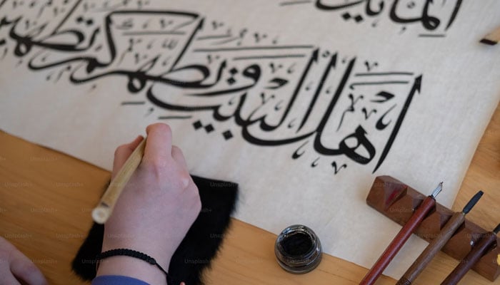 A representational image of a calligrapher working on canvas. — Unsplash