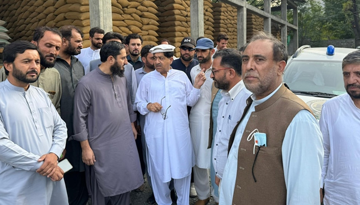 Khyber Pakhtunkhwa Minister for Food Muhammad Zahir Shah talking to a citizen during a visit to a grain warehouse can be seen in this image released on September 25، 2024. — Facebook/Zahir Shah Toru