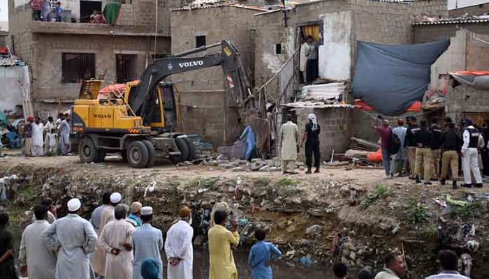 Karachi Development Authority (KDA) staffers demolishing the illegal constructions during anti-encroachment operation on the Gujar Nullah at Gulbarg area. — Online/File