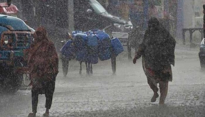 Women walk amid heavy rainfall in Sindh and Punjab. — AFP/File