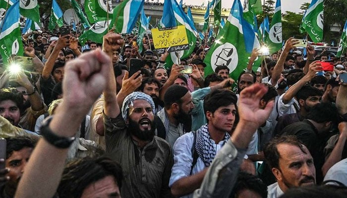 JI supporters and activists hold party flags during a protest in Islamabad on July 26, 2024. — AFP