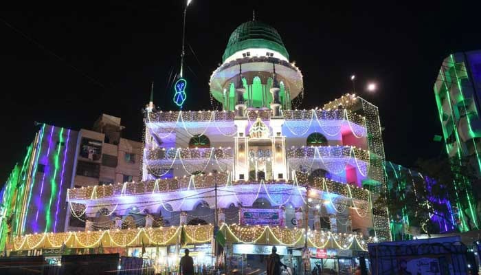 This representational image shows Muslims stand outside an illuminated mosque during celebrations marking the Eid Milad un Nabi in Karachi on November 29, 2017. — AFP