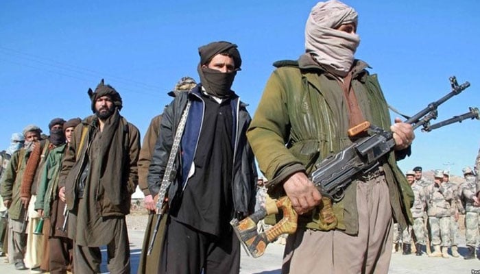 Afghan Taliban standing in a line with their weapons. — AFP/File