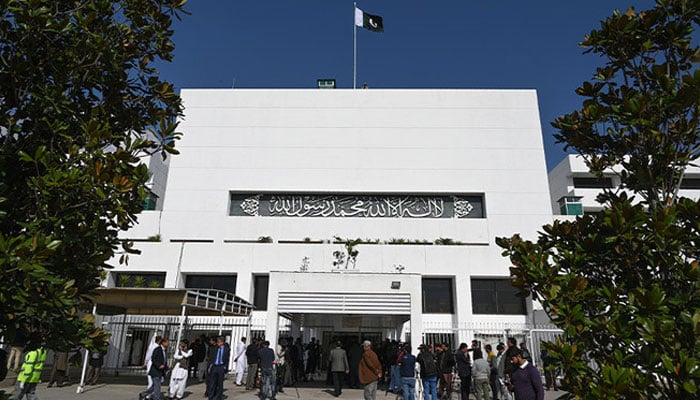 Media personnel gather outside the parliament building during a joint session in Islamabad on February 28, 2019. — AFP