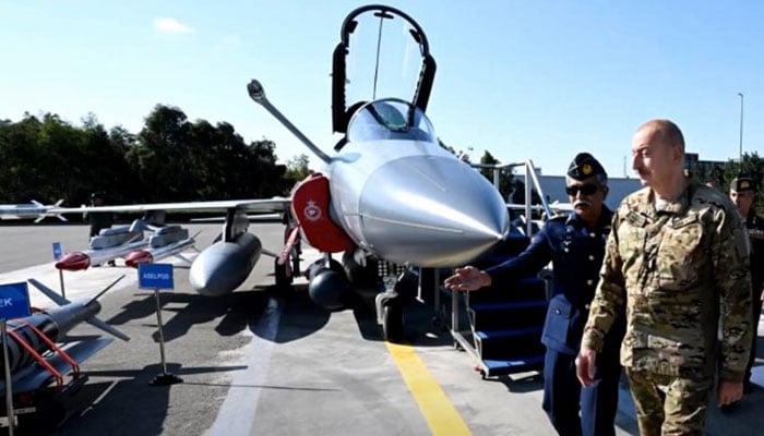 Azerbaijans President Ilham Aliyev walks past by a JF-17 fighter aircraft on display. — Screengrab via YouTube/@politikaUA2021