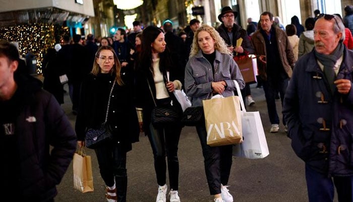 Shoppers walk along a shopping street in Rome, Italy, December 23, 2022. — Reuters